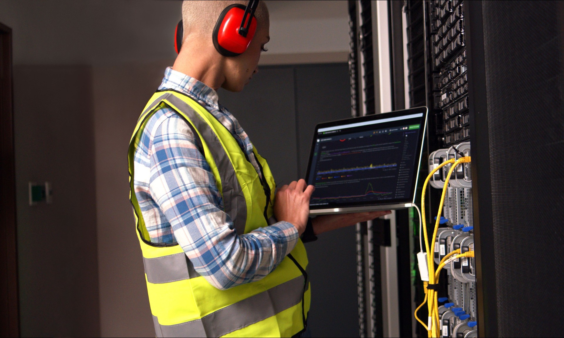 Software engineer, working or laptop in server room for database or reading metrics for troubleshooting a glitch. Person, IT support or technology to test CPU or diagnostic tool on system performance